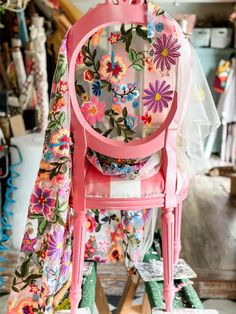 a pink chair with flowers painted on it