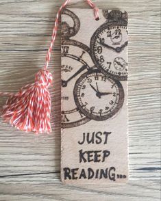 a bookmark with an image of clocks and the words just keep reading on it