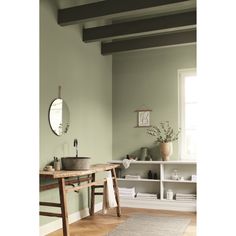 a bathroom with green walls and wooden flooring in the room, along with a sink