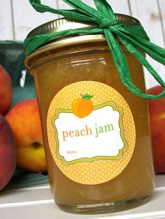 a jar filled with peach jam next to apples