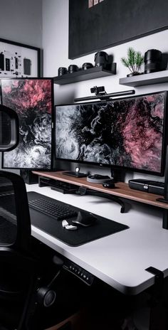 two computer monitors sitting next to each other on top of a white desk in front of a window