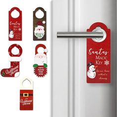 christmas door hangers with santa and snowmen on them, hanging from the side of a refrigerator