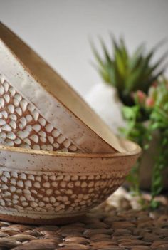 three bowls sitting next to each other on top of a woven tablecloth covered floor