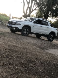 a white truck parked on top of a dirt field