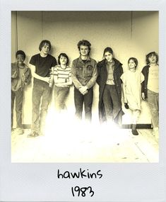 a group of people standing next to each other in front of a wall with the words hawks 1989 written on it