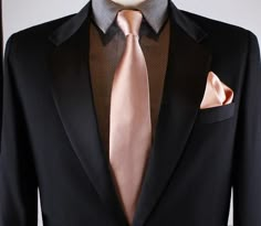 a black suit with a pink tie and pocket square