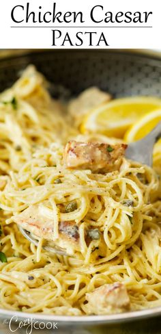 chicken caeser pasta in a pan with lemons and parsley on the side