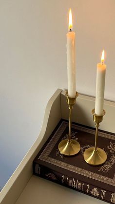 two candles are sitting on top of a book