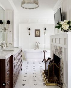 a white bathroom with a fireplace, sink and bathtub in it's center