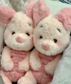 two pink and white stuffed animals sitting next to each other