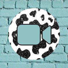 a brick wall with a black and white cow print pattern on it, which has an empty speech bubble in the center