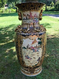 a large vase sitting on top of a lush green field