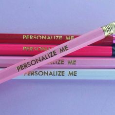 three personalized pencils sitting next to each other on top of a purple surface