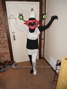 a person in a costume that looks like a cat with green eyes and mouth rings