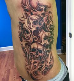 a man's thigh with skulls and flames on it