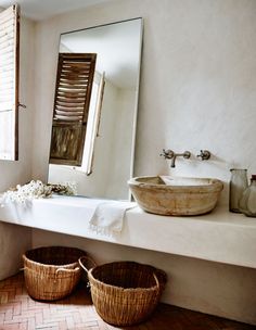 a bathroom with two baskets and a large mirror