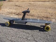 a skateboard is sitting on the road in front of some dry grass and weeds