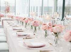 a long table is set with pink flowers and place settings for an elegant wedding reception