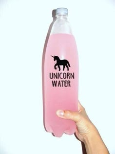 a person holding up a pink water bottle with an unicorn on it's side