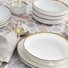 a table topped with white and gold plates