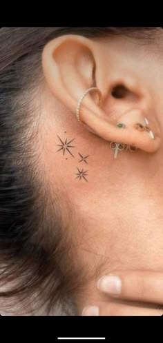 a woman's ear with three small stars on it