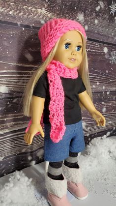 a doll with blonde hair and blue eyes wearing a pink knitted hat and scarf