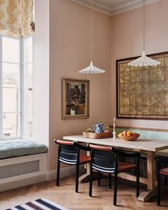 a dining room table with chairs and a bench in front of a large painting on the wall