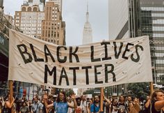 a group of people holding up a black lives matter banner