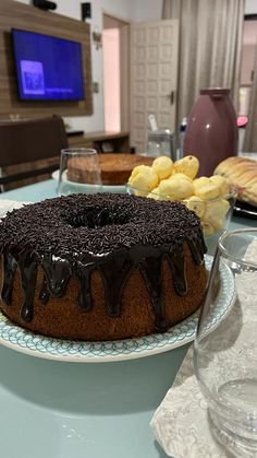 a chocolate cake sitting on top of a white plate next to a glass of water