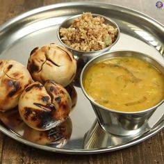 a metal plate topped with food next to a bowl of soup