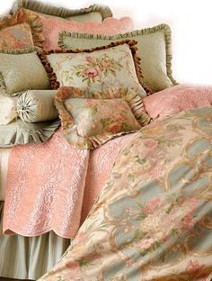 a bed covered in lots of pillows and blankets