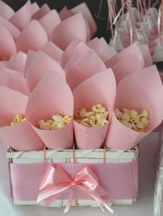 pink paper bags filled with popcorn on top of a table