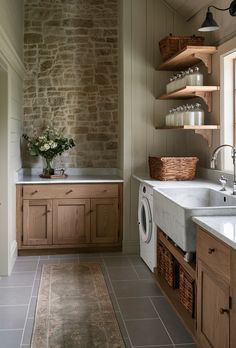 a washer and dryer in a small room with stonework on the walls