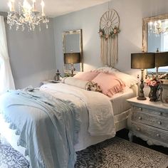 a white bed sitting in a bedroom next to two tables with lamps on top of it