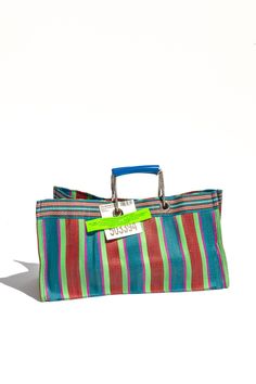 Made from recycled plastics, this wide bag is both eco-friendly and stylish. Plus, the colorful stripes add a vibrant twist to any outfit. Perfect for trips to the grocery store, beach, or anywhere you need a durable and fashionable tote. "This fabric is often seen in India and is widely used throughout for bags and storage. We've never found any surplus of this material in good condition to repurpose or in a good combination of colors. One day, we saw very large and vibrant storage bags hauling Reusable Rectangular Beach Bag For Shopping, Multicolor Tote Bag With Striped Lining, Striped Tote Beach Bag For Shopping, Striped Rectangular Beach Bag For Shopping, Rectangular Beach Bag With Striped Lining, Rectangular Beach Bag With Striped Lining For Travel, Striped Rectangular Beach Bag, Summer Rectangular Bag With Striped Lining, Striped Rectangular Beach Bag For Everyday Use