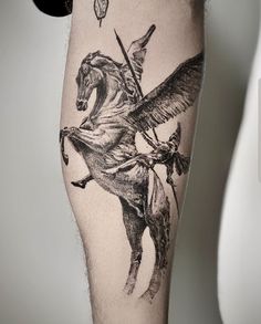 a man's leg with an eagle and horse tattoo on it