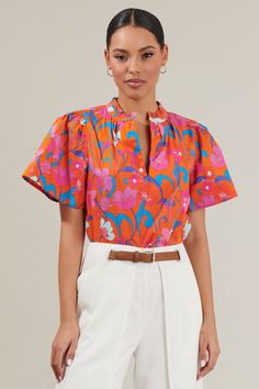 For the perfect finish to any outfit, you need the Baila Floral Inaya Split Neck Top! A pretty blue and pink floral motifs sits on an orange background. It features short bell sleeves framing a mock neck and a split neckline. Wear it tucked into any shorts or pants or leave it as is. - Split neckline- Breathable- Flowry sleeves- Ruffle trim- Color: Orange Blue MultiSize + Fit - Model is 5'8" and wearing size XS- Measurements taken from size S - Chest: 20 1/2"- Length: 25" Fabric Self:100%Cotton Patterned Blouse Outfit, Short Bell Sleeves, Orange Background, Blouse Outfit, Trim Color, Blouse Patterns, Floral Motifs, Blue And Pink, Cotton Blouses