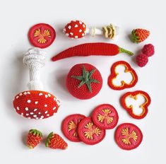 crocheted food items displayed on white surface including strawberries, tomatoes and mushrooms