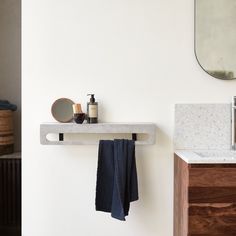 a bathroom with a sink, mirror and towel rack on the wall next to it