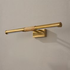 a gold toilet brush mounted on the wall