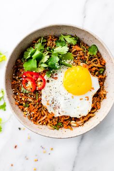 a bowl filled with rice, vegetables and an egg