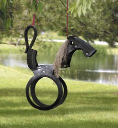 a horse shaped swing hanging from a tree