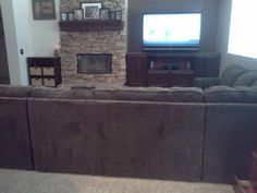 a living room filled with furniture and a flat screen tv on top of a fireplace