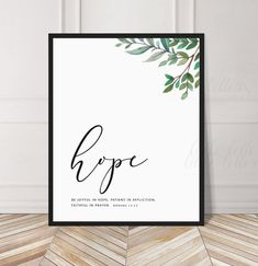 a poster with the word hope written in cursive writing, on top of a chevron wood floor