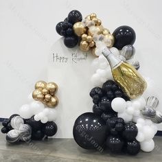 black and gold balloon arch with champagne bottle