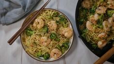 shrimp and broccoli noodle stir fry in a skillet with chopsticks