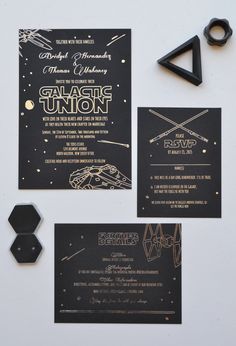 the star wars wedding stationery is laid out on a white surface with black and gold accents