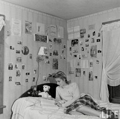 a woman sitting on top of a bed next to a stuffed animal in a bedroom