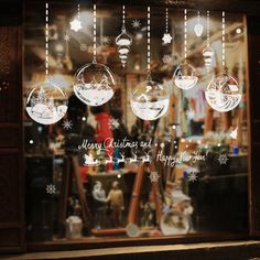 a window with ornaments hanging from it's side and the words merry christmas written in white