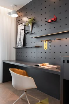 a desk with a chair and shelves on the wall